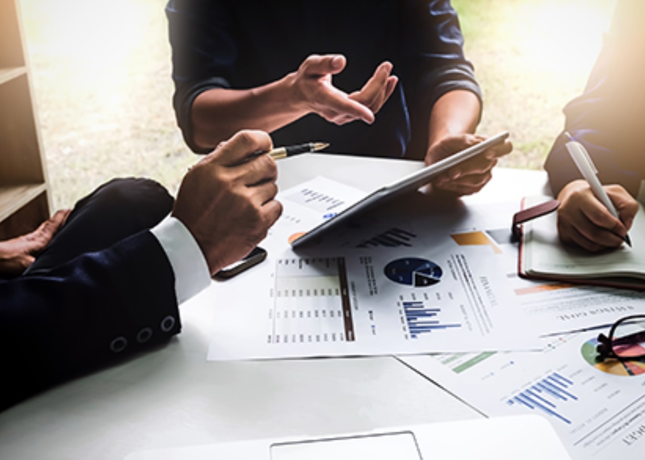 three people meeting with documents